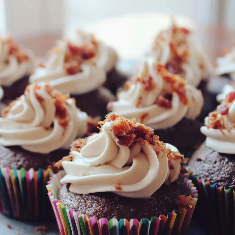 Chocolate cupcakes topped with tall swirls of white frosting