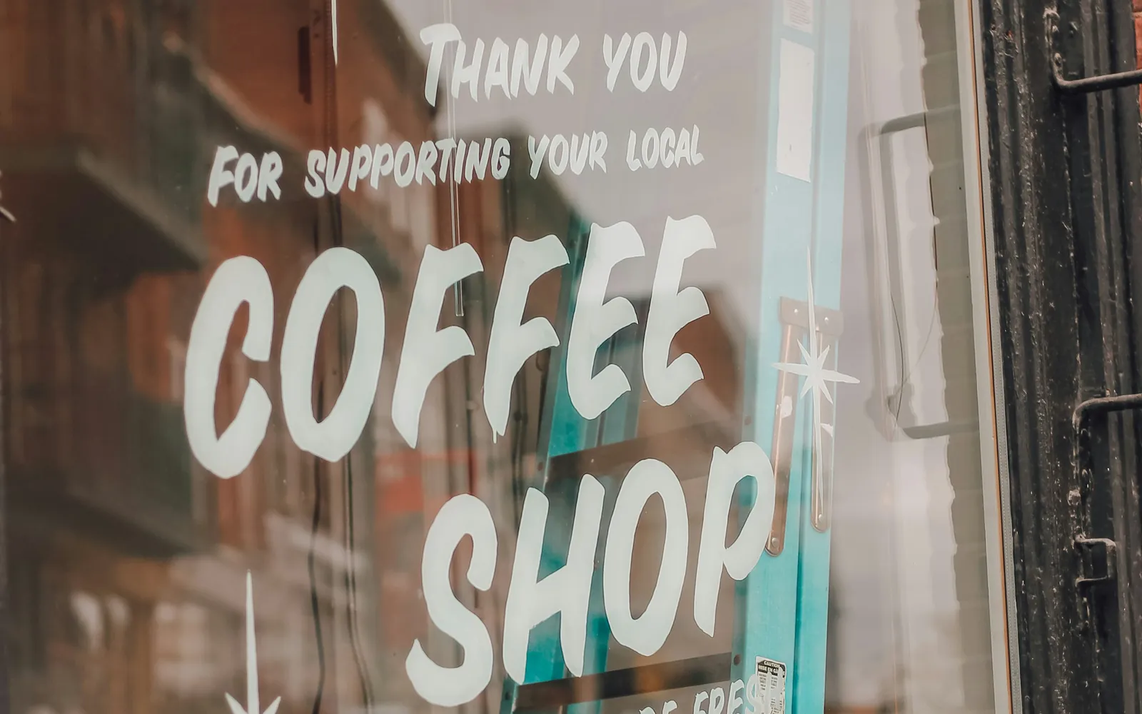A café window with hand-painted Coffee Shop lettering