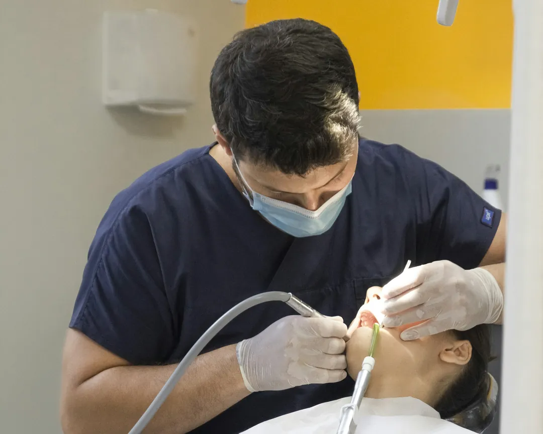 A dentist carefully treating a patient in the chair